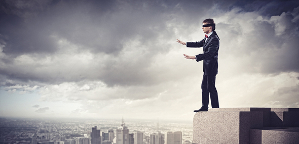 Image of businessman in blindfold standing on top of building